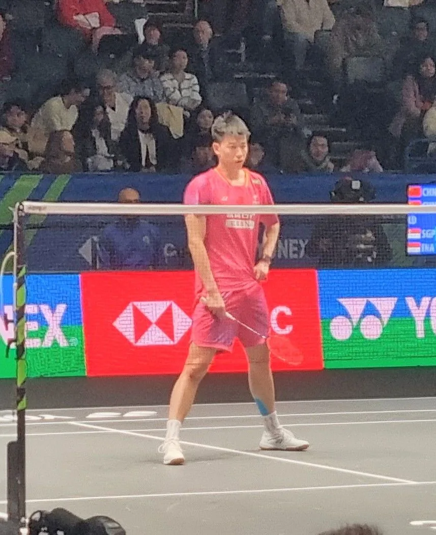 China's Feng Yan Zhe in a pink shirt playing on court at the All England 2026