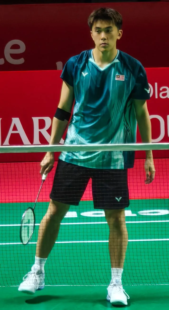 Hoo Pang Ron in a green shirt standing on court holding a racket at the Indonesia Open 2026