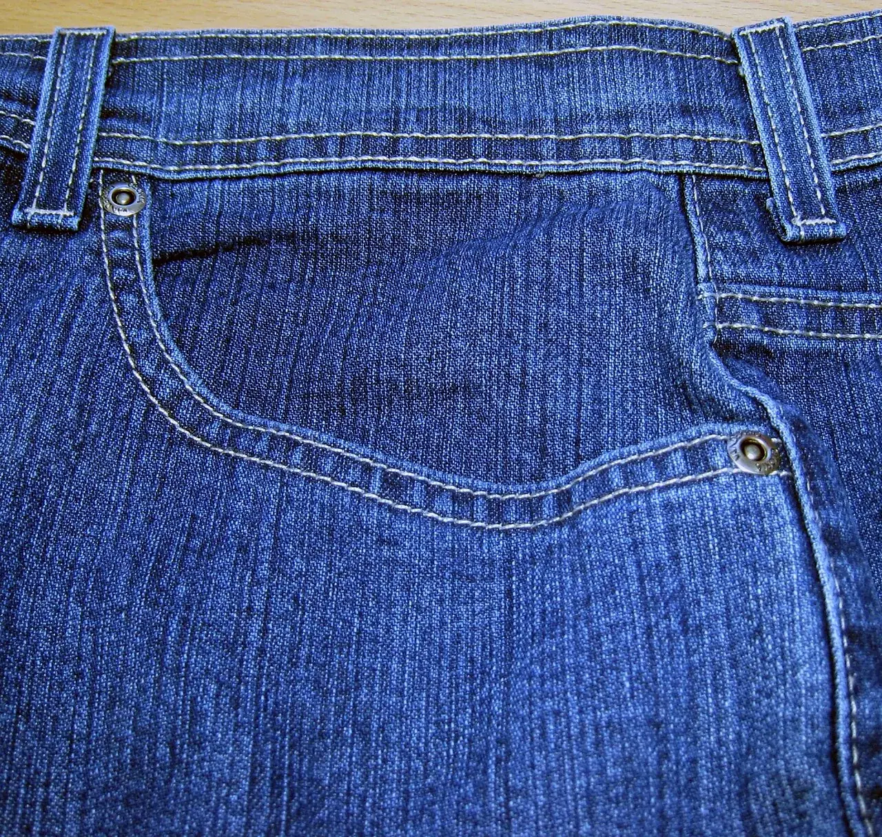 Poket depan seluar jeans dengan poket kecil dan paku rivet