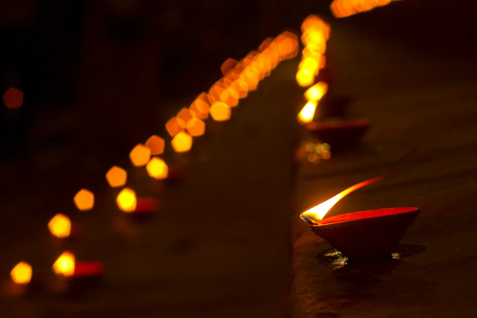 Deretan pelita diya menyala dalam gelap, simbol sambutan tarikh Deepavali